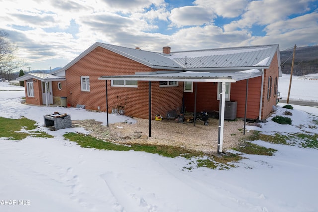 snow covered property featuring central air condition unit