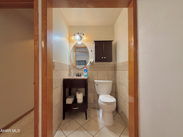 bathroom featuring tile patterned flooring, tile walls, and toilet