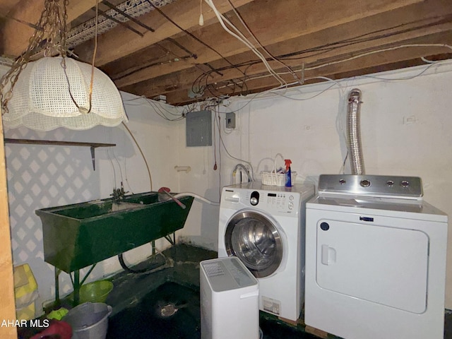 laundry room featuring electric panel, washing machine and clothes dryer, and sink