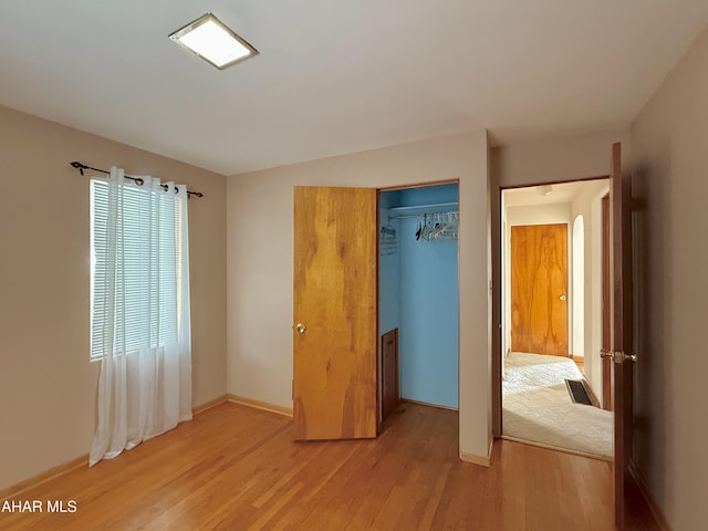 unfurnished bedroom featuring a closet and light hardwood / wood-style flooring