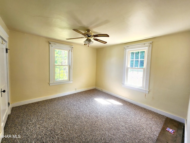 spare room featuring dark hardwood / wood-style flooring and ceiling fan