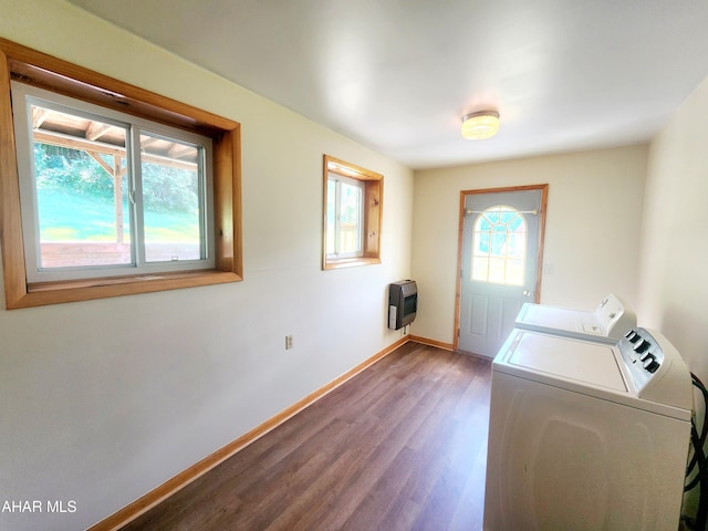 clothes washing area with washer and clothes dryer, hardwood / wood-style flooring, and heating unit