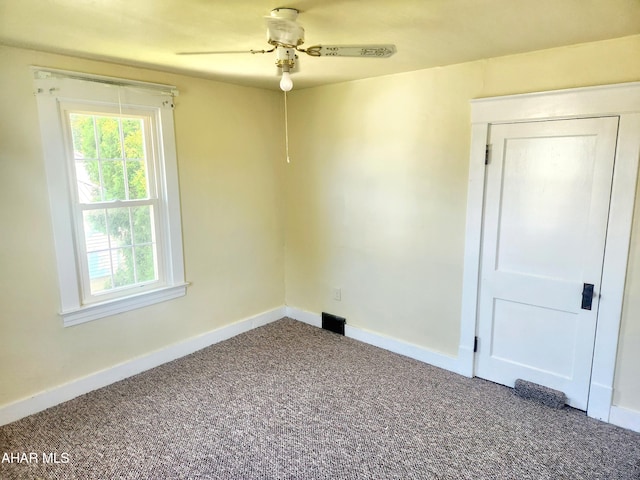 carpeted spare room featuring ceiling fan