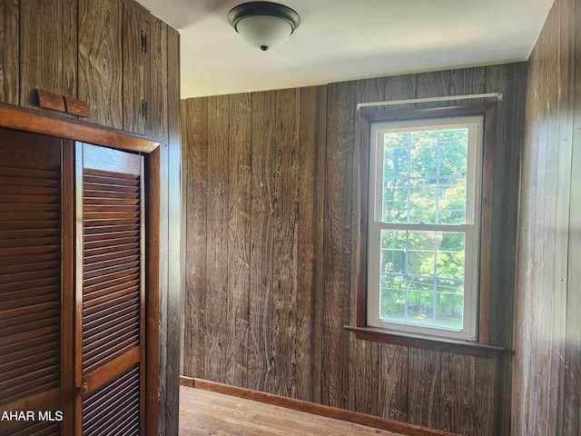 empty room featuring wood walls and light wood-type flooring