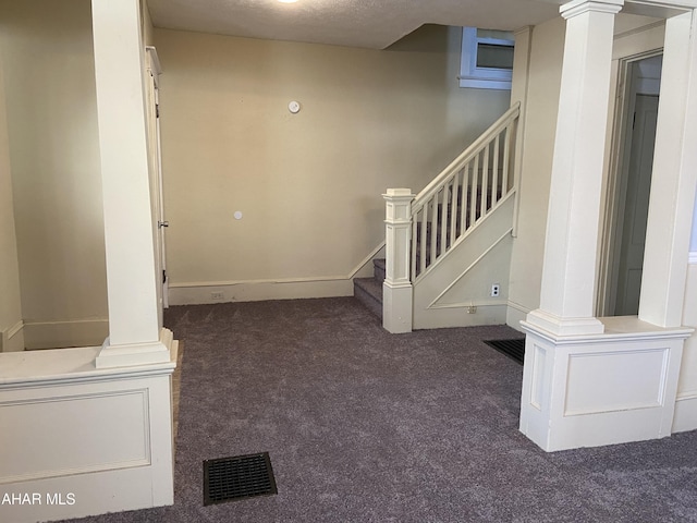 interior space with a textured ceiling and carpet floors