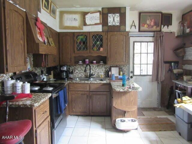 210 Hazel St, Johnstown, PA 15909 - kitchen with stainless steel range with electric cooktop, a sink, tasteful backsplash, and brown cabinets