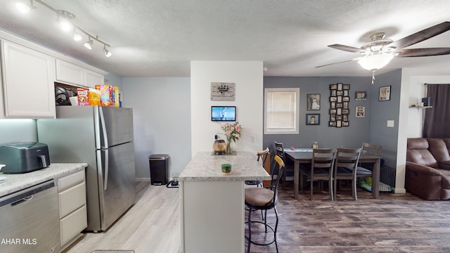 1407 N 5th Ave, Altoona, PA 16601 - kitchen with appliances with stainless steel finishes, a kitchen breakfast bar, light wood-style floors, a peninsula, and light countertops