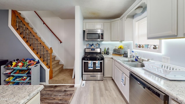 1407 N 5th Ave, Altoona, PA 16601 - kitchen featuring appliances with stainless steel finishes, light wood-style floors, white cabinets, and a textured ceiling