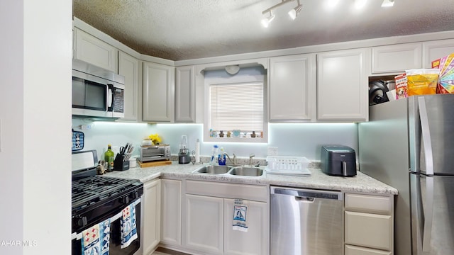 1407 N 5th Ave, Altoona, PA 16601 - kitchen featuring appliances with stainless steel finishes, light countertops, white cabinets, and a textured ceiling