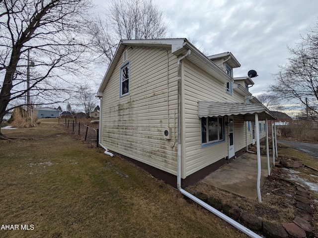 view of property exterior featuring a patio and fence