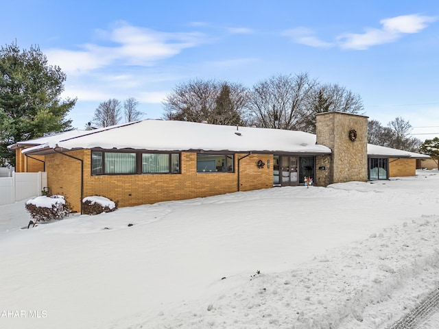 view of snow covered back of property