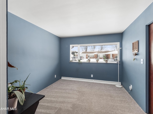 unfurnished room featuring carpet floors and a baseboard heating unit