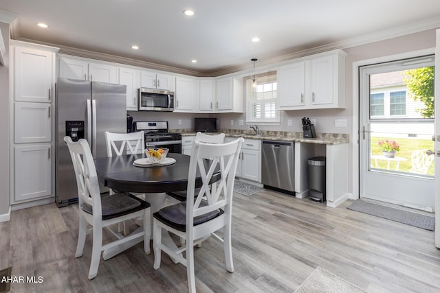 kitchen featuring white cabinetry, a wealth of natural light, decorative light fixtures, and appliances with stainless steel finishes