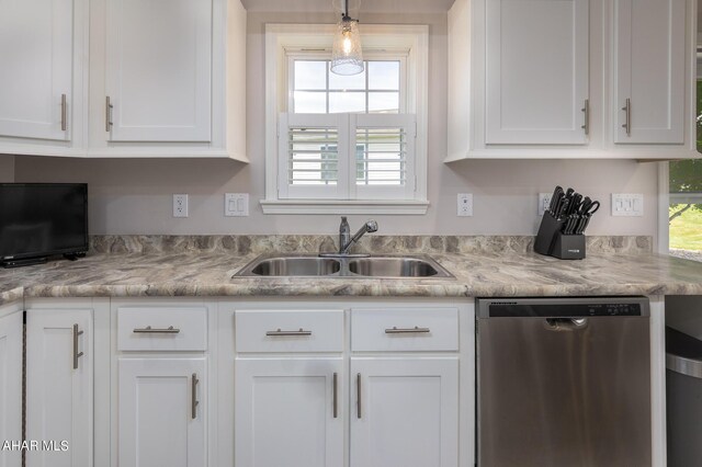 kitchen with light stone countertops, white cabinetry, dishwasher, hanging light fixtures, and sink