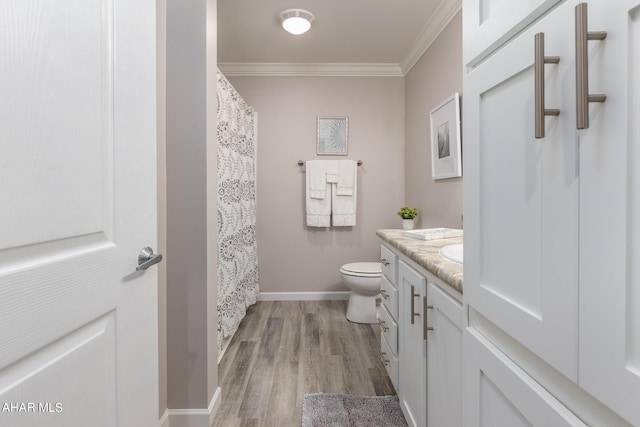 bathroom featuring hardwood / wood-style flooring, vanity, toilet, and ornamental molding