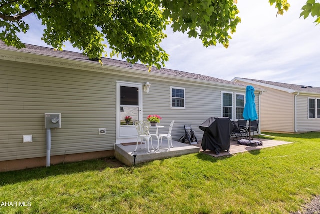 back of property with a patio area and a yard