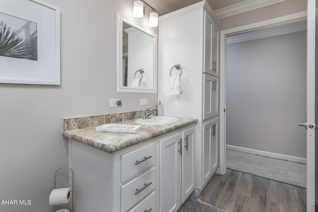 bathroom featuring wood-type flooring, vanity, and ornamental molding