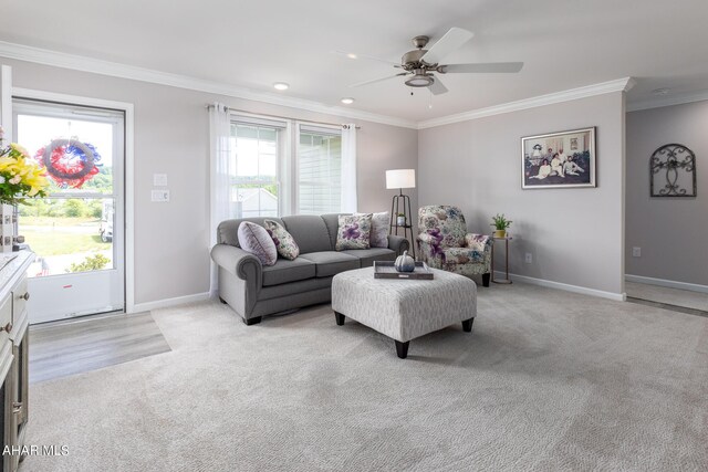 carpeted living room with ceiling fan and ornamental molding