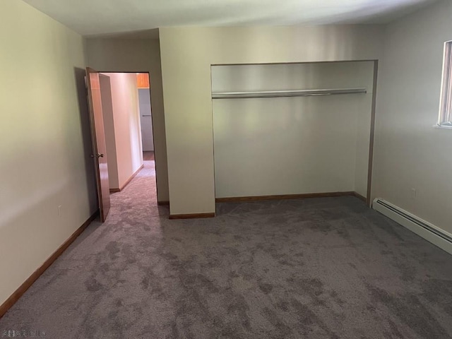 unfurnished bedroom with dark colored carpet, a closet, and a baseboard heating unit