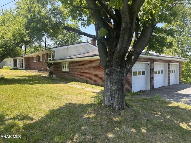 view of side of property featuring a yard and a garage