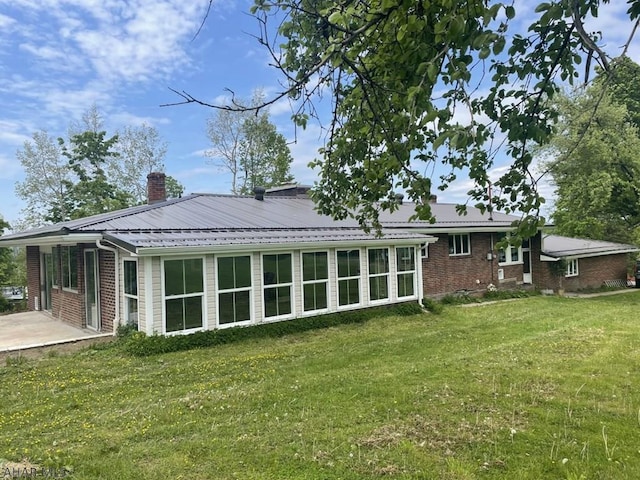 rear view of house featuring a patio area and a yard