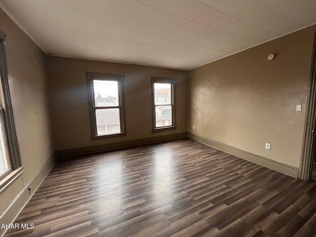 unfurnished room with dark hardwood / wood-style flooring and ornamental molding