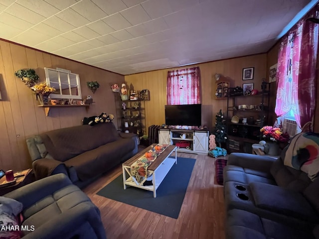 living room with hardwood / wood-style floors, wood walls, and a wealth of natural light