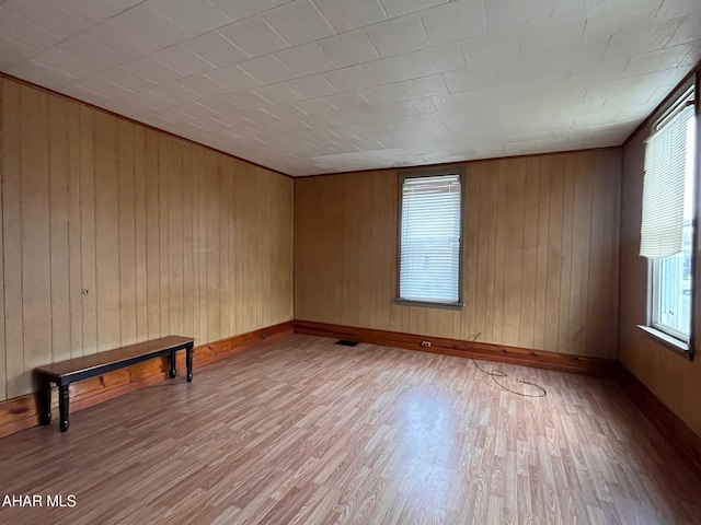 spare room with hardwood / wood-style flooring and wooden walls