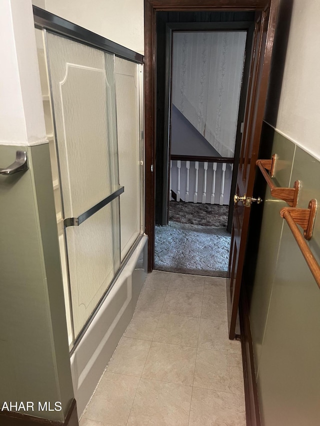 bathroom featuring enclosed tub / shower combo and tile patterned flooring