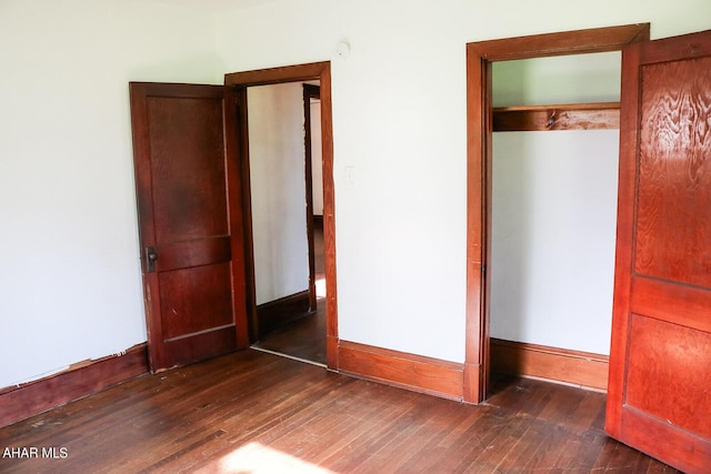 unfurnished bedroom featuring a closet and dark hardwood / wood-style floors