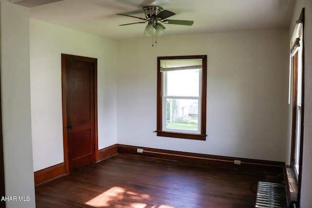 unfurnished room with ceiling fan and dark hardwood / wood-style flooring