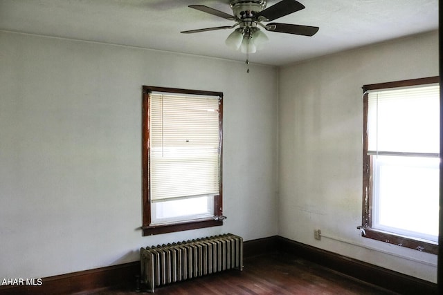 unfurnished room with ceiling fan, radiator heating unit, and dark hardwood / wood-style floors