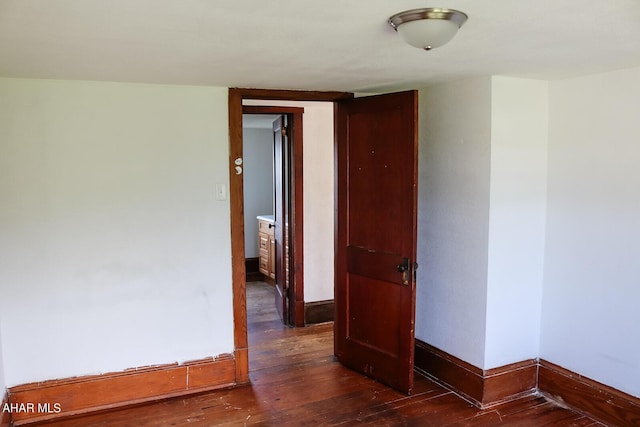 unfurnished room with dark wood-type flooring