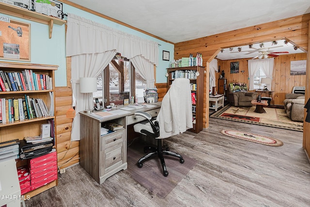 home office with plenty of natural light, wood-type flooring, crown molding, and wood walls