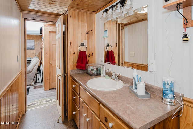 bathroom featuring vanity, wood walls, and wooden ceiling