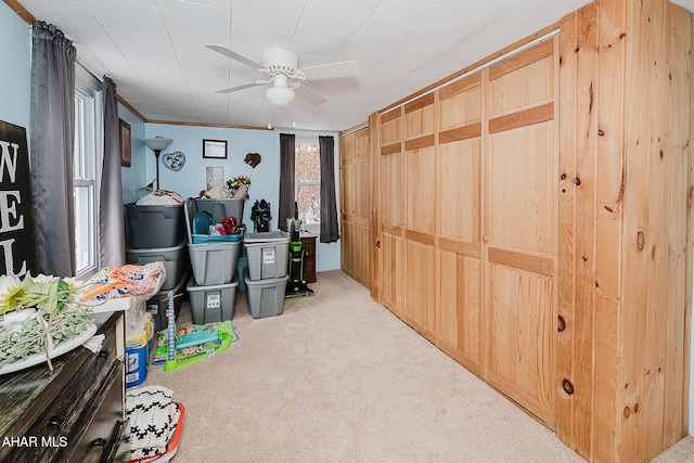 miscellaneous room featuring light carpet, ceiling fan, and crown molding