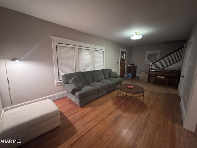 living room with stairway, baseboards, and hardwood / wood-style flooring