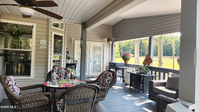 sunroom with vaulted ceiling with beams, ceiling fan, and a wealth of natural light