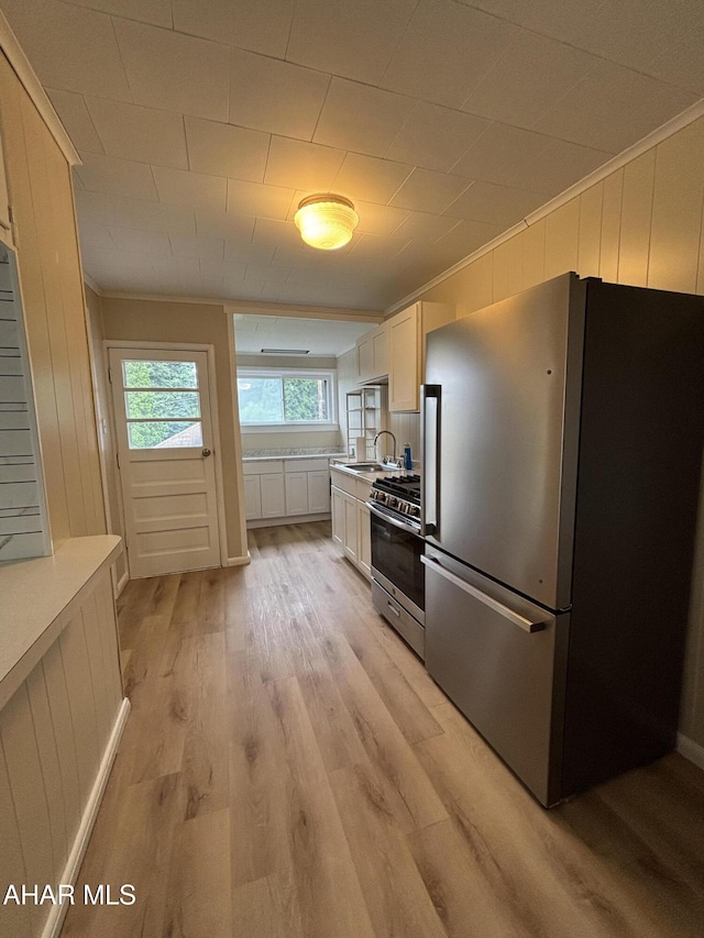 1413 17th Ave, Altoona, PA 16601 - kitchen with stainless steel appliances, crown molding, light wood-style floors, white cabinetry, and light countertops