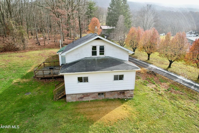 view of home's exterior featuring a lawn and a deck