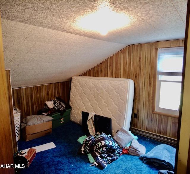 carpeted bedroom with wood walls and vaulted ceiling