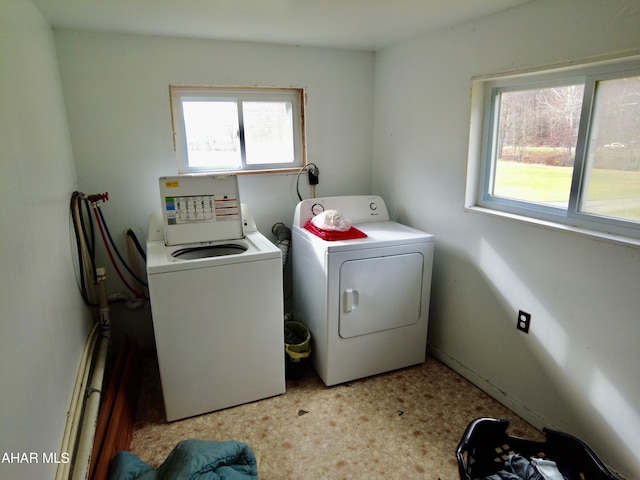 laundry room with washing machine and clothes dryer and a healthy amount of sunlight