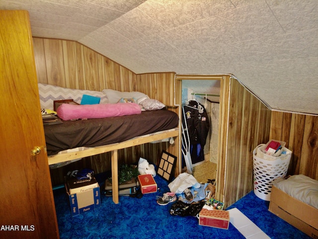 bedroom featuring wooden walls, carpet floors, and lofted ceiling