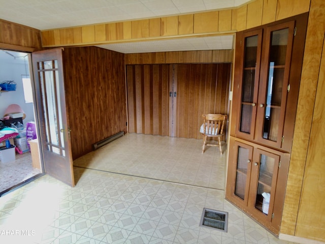 corridor featuring wood walls and baseboard heating