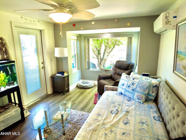 living room featuring an AC wall unit, ceiling fan, and wood-type flooring