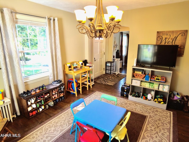 playroom featuring a textured ceiling, dark hardwood / wood-style floors, and a notable chandelier