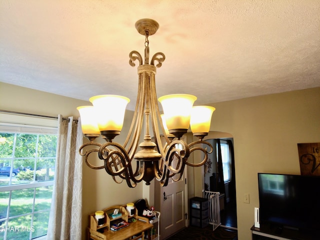 details featuring a textured ceiling and a notable chandelier