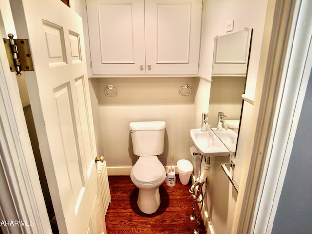 bathroom featuring hardwood / wood-style flooring, toilet, and sink