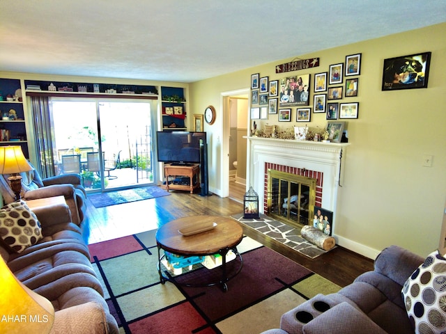 living room with hardwood / wood-style flooring and a brick fireplace