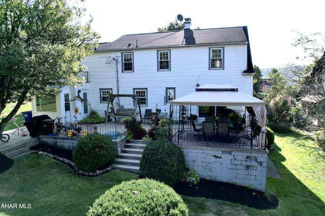 back of house featuring a gazebo and a lawn